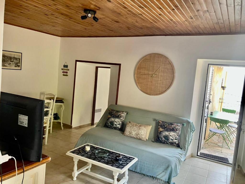 Village de Pozzo appart. 4 pers. في Brando: غرفة معيشة مع أريكة وتلفزيون