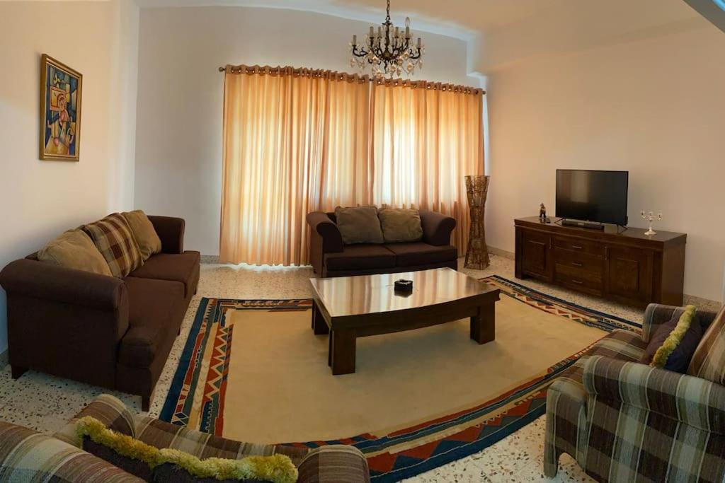 a living room with a couch and a coffee table at Lovely 3 Bedrooms Apartment at city center in Bayt Jālā