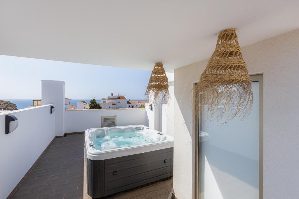 y baño con bañera de hidromasaje en el balcón. en Burgau Village and Sea, en Burgau