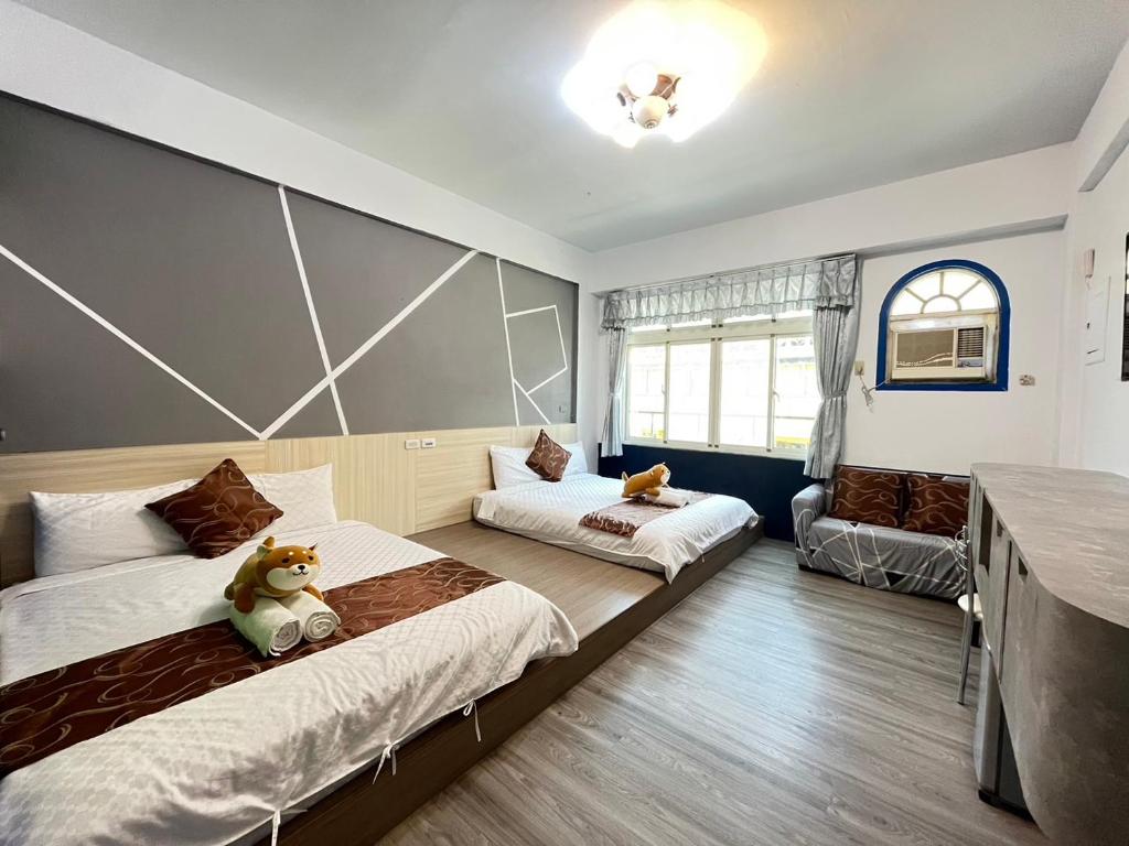 1 dormitorio con 2 camas y sofá en Rihchun Homestay, en Hengchun