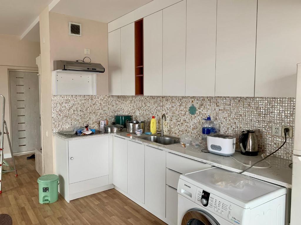 a kitchen with white cabinets and a washer at 2 bedrooms apartment in Ulaanbaatar
