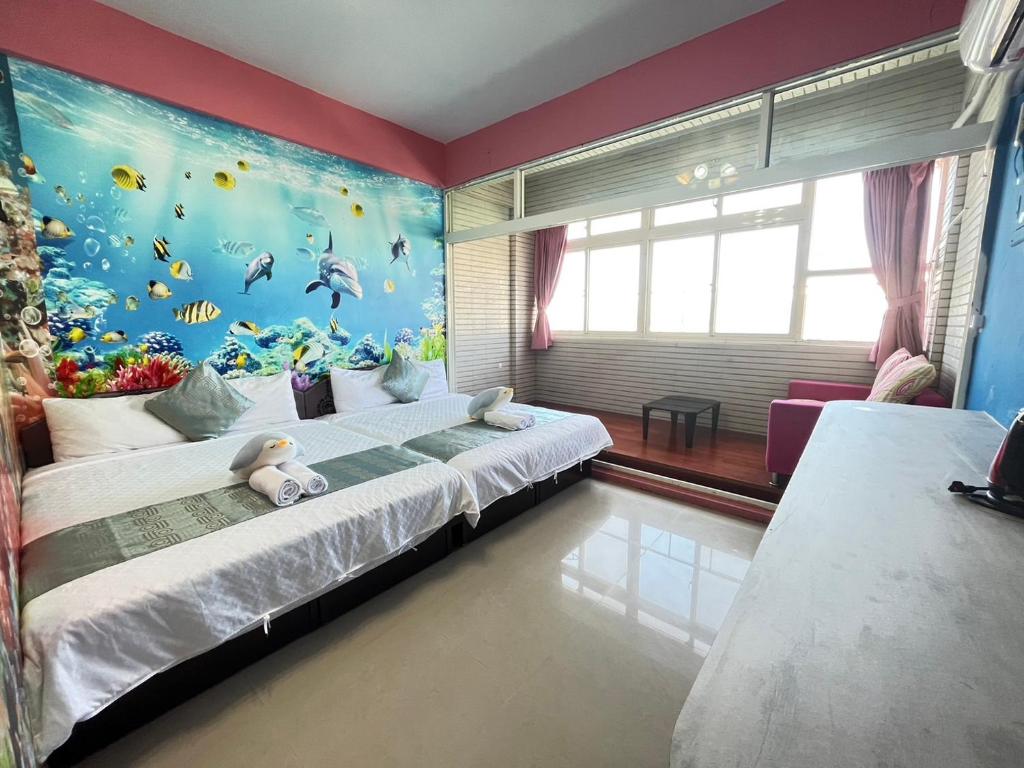 a bedroom with a bed with a fish mural at Rihchun Homestay in Hengchun South Gate
