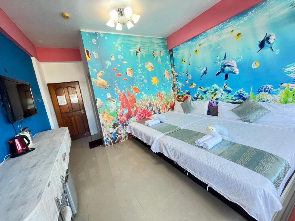 a bedroom with a bed with a fish mural at Rihchun Homestay in Hengchun South Gate