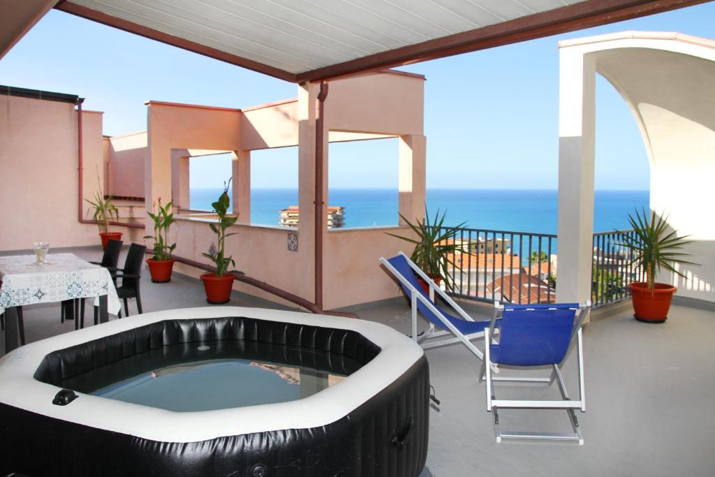 bañera de hidromasaje en el balcón con vistas al océano en Attico vista mare con terrazza e spa riscaldata, en Santo Stefano di Camastra
