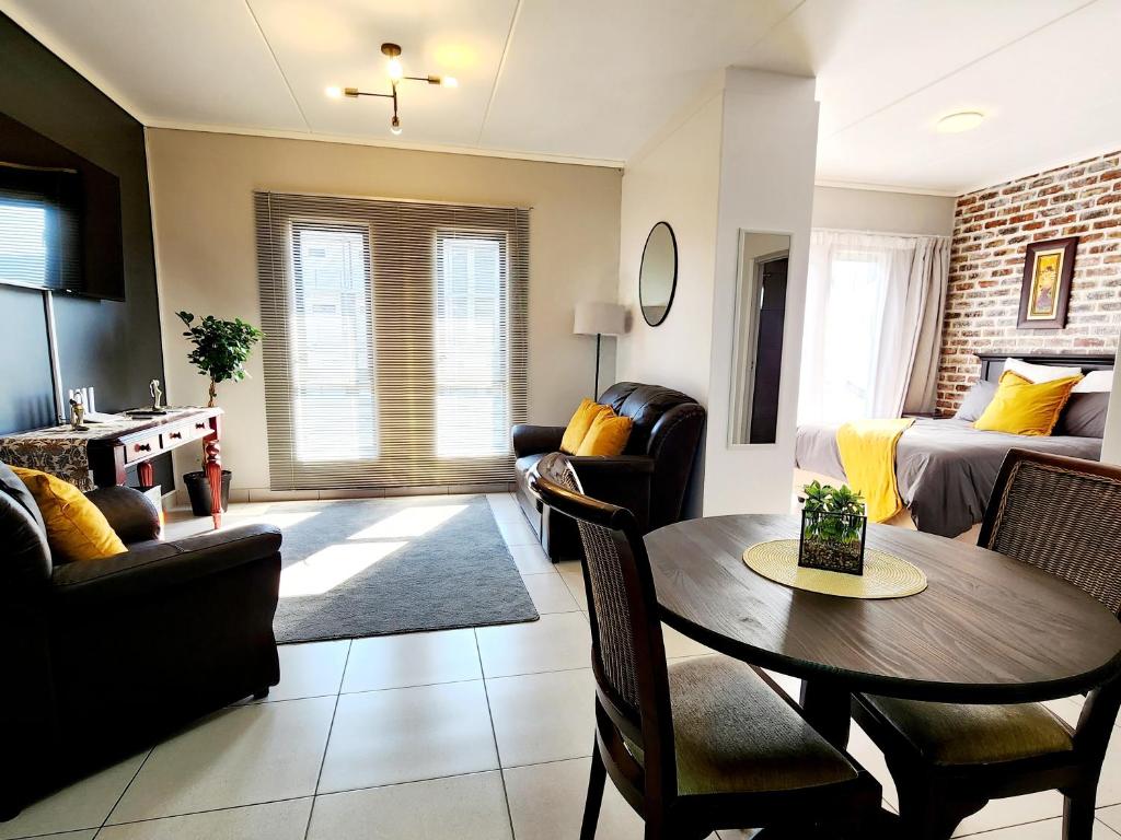 a living room with a table and chairs and a couch at Luxury Lowveld Apartment in Nelspruit