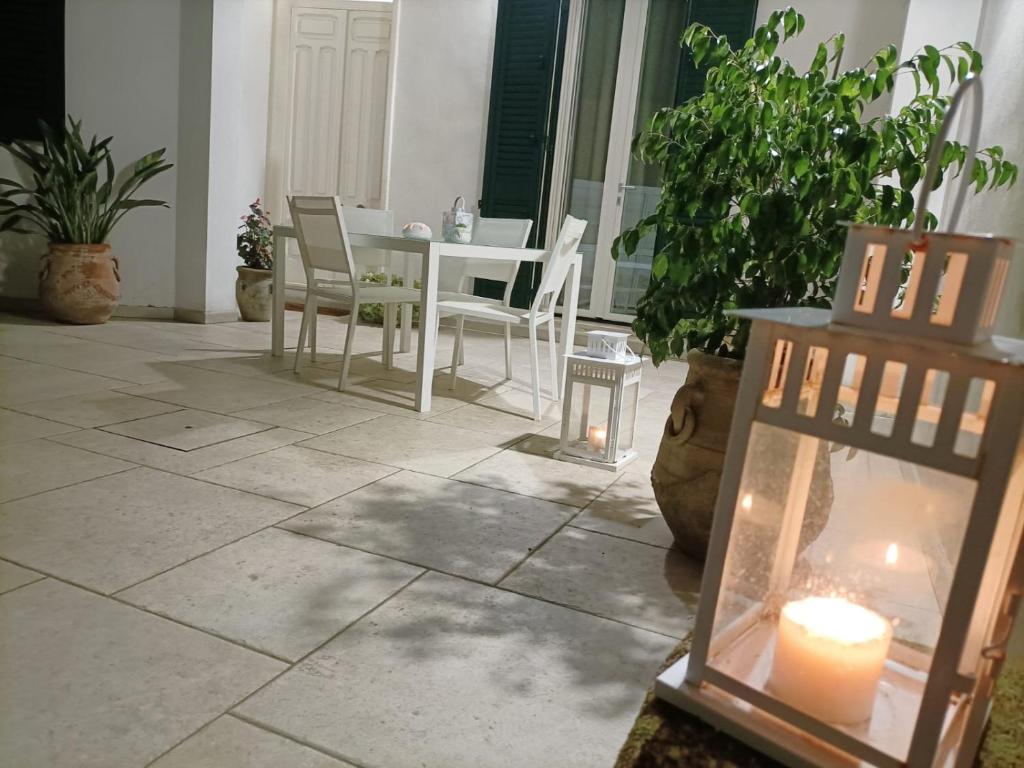 a patio with a table and chairs and a candle at Il ponte sul Salento in Trepuzzi