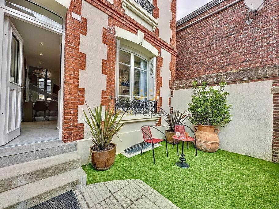 une cour avec deux chaises et des plantes dans un bâtiment dans l'établissement Villa Victoria YourHostHelper, à Deauville