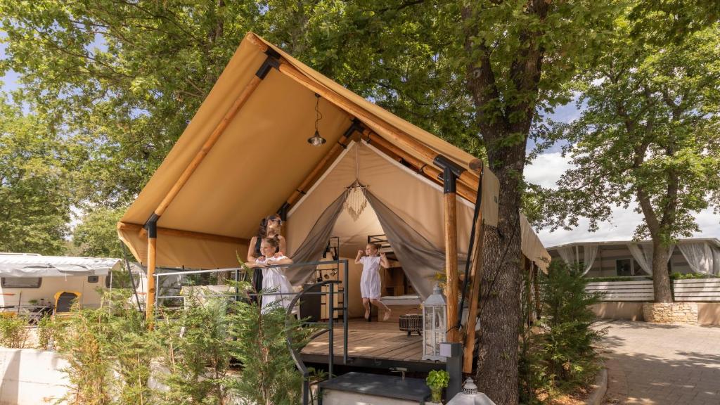 a tent with two people standing inside of it at Polidor Glamping Resort in Poreč