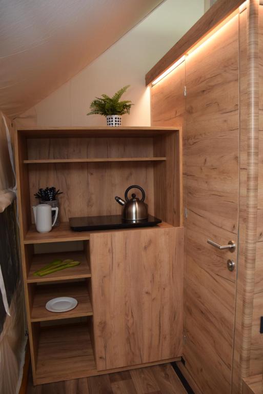 a wooden cabinet with a tea kettle in a room at Polidor Glamping Resort in Poreč