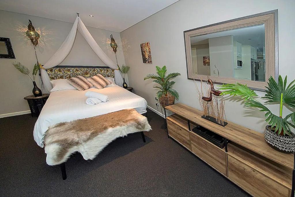 a bedroom with a large bed and a large mirror at ZANZIBAR FANTASTIC 1 Bedroom APARTMENT in Gold Coast