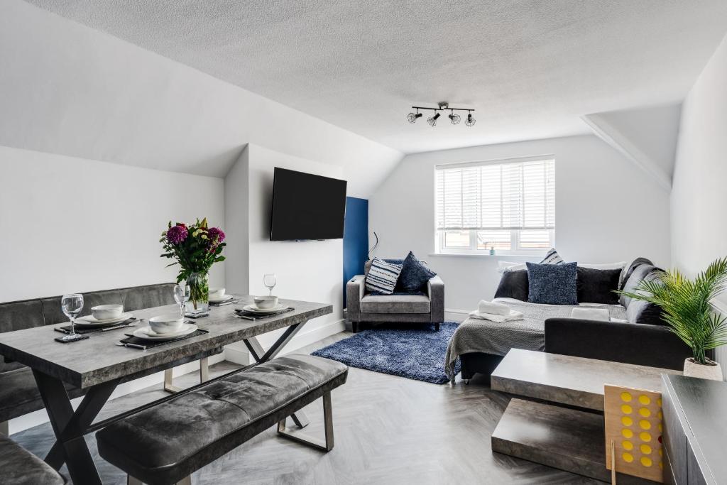 sala de estar con mesa y sofá en St David's - Stylish 2 bed apartment, free parking, close to beach en Lytham St Annes
