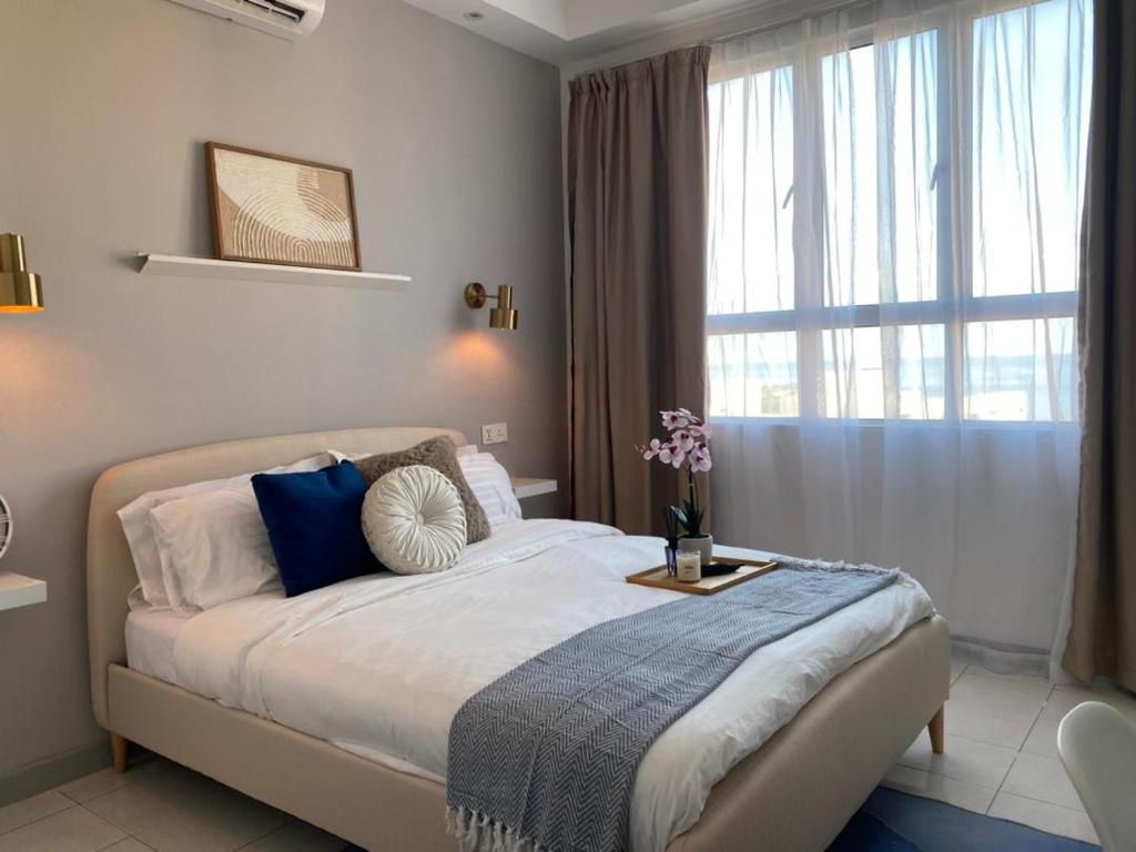 um quarto com uma cama grande e uma janela em The Cotton Bleu Homestay em Kuala Terengganu