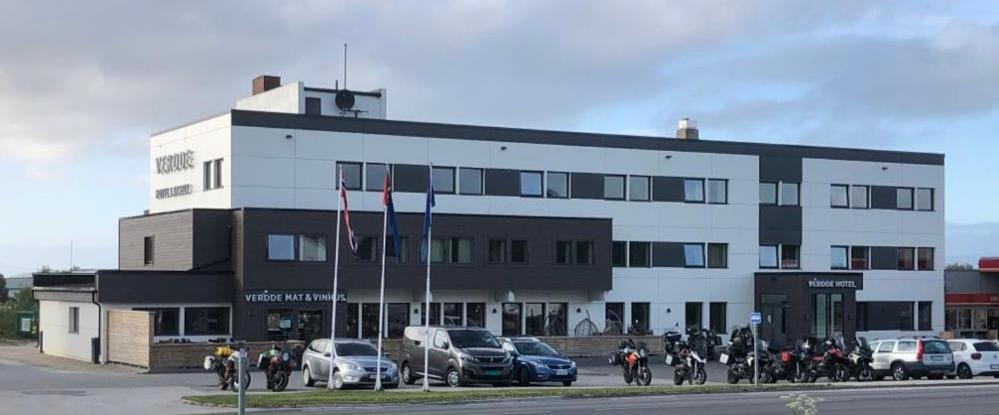 un grand bâtiment avec des motos garées devant lui dans l'établissement Verdde Hotel Lakselv, à Lakselv