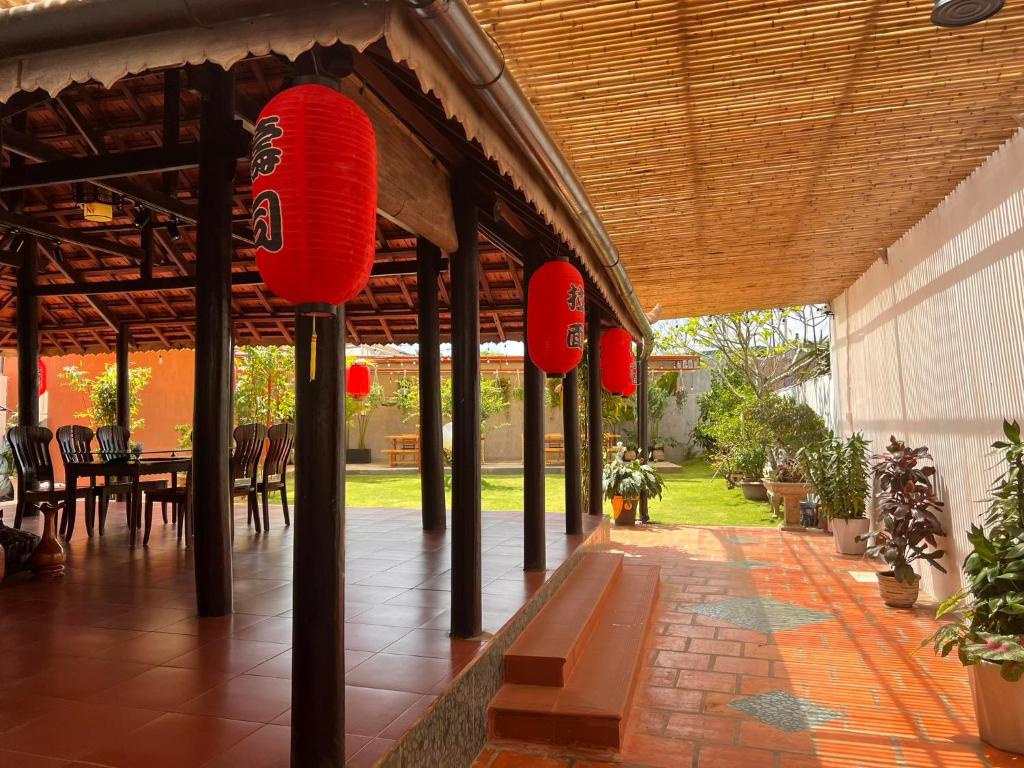 un patio con faroles rojos, mesa y sillas en MOONLIGHT Homestay & Hotel en Pleiku