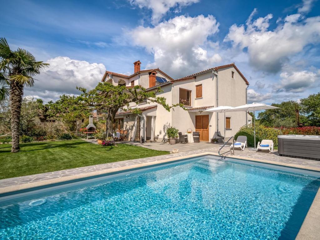 a villa with a swimming pool in front of a house at Villa Marina Vosteni in Vošteni