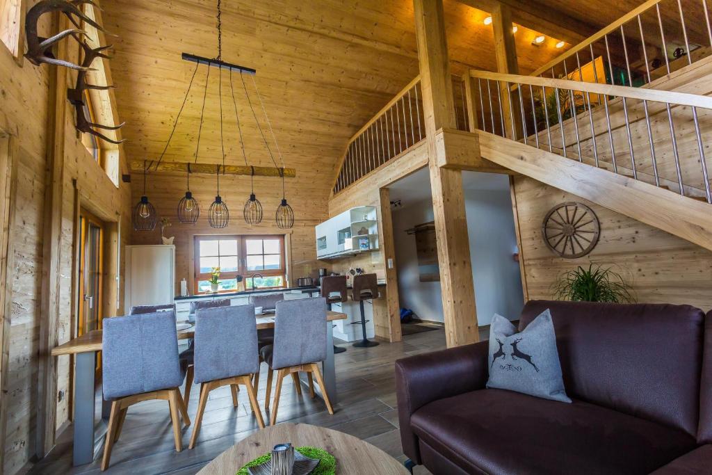 a dining room and living room with a table and chairs at Chalet Hüttenzauber in Mehlmeisel