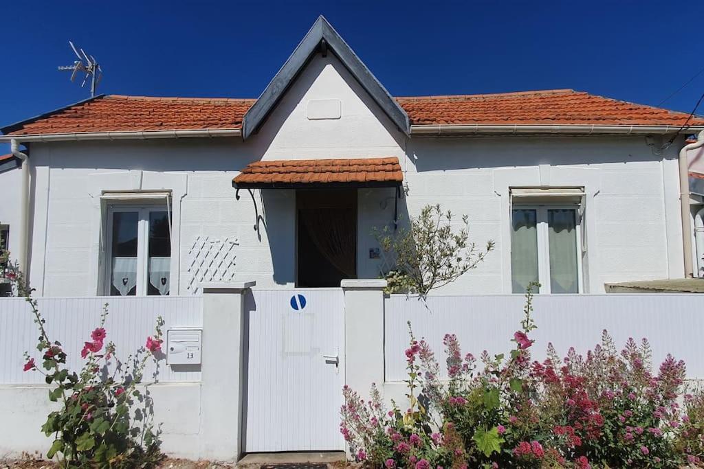 une maison blanche avec une clôture blanche dans l'établissement Charmante maisonnette proche plage, à Châtelaillon-Plage