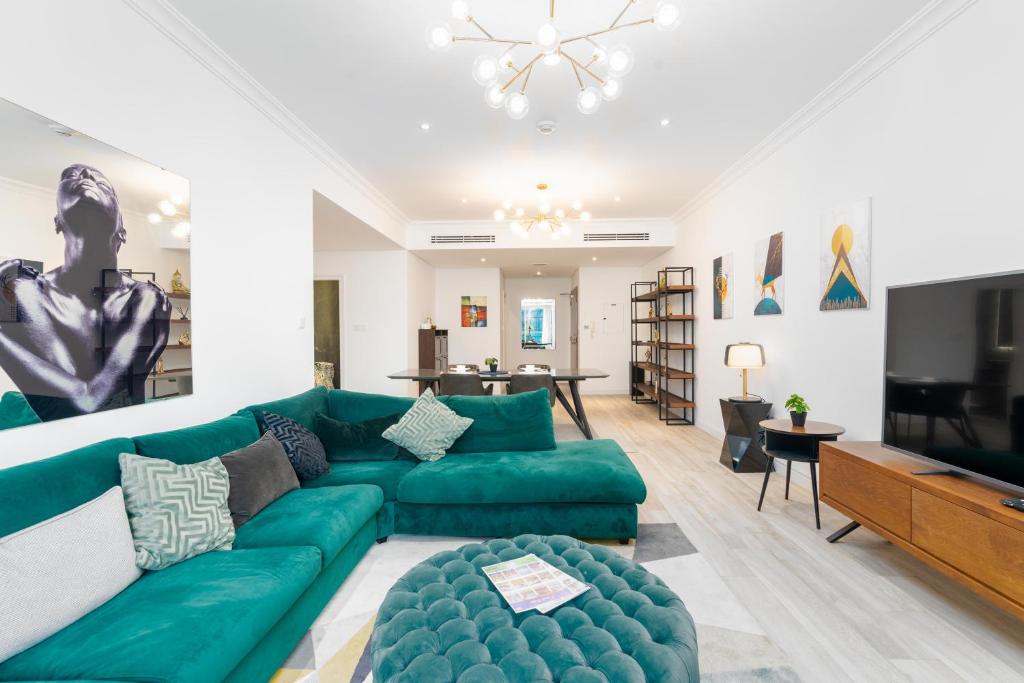 uma sala de estar com um sofá verde e uma televisão de ecrã plano em Marina Heights Tower - Vigor Vacations Homes em Dubai