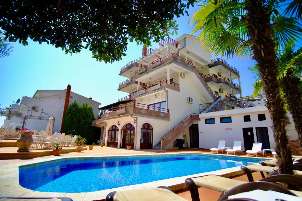 a building with a swimming pool in front of a building at Hotel Kleopatra in Ulcinj