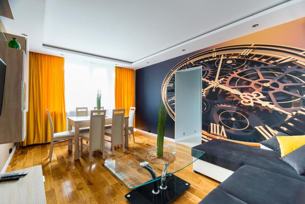 a living room with a large clock on the wall at Apartament Lelewela in Częstochowa