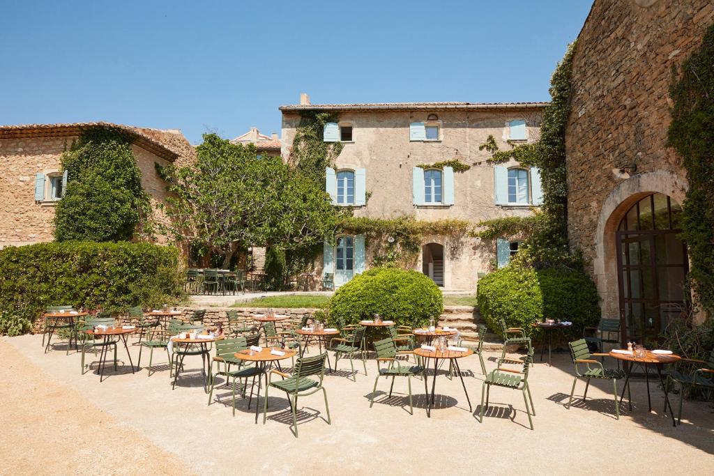 a courtyard with tables and chairs in front of a building at La Bastide du Mourre in Oppède