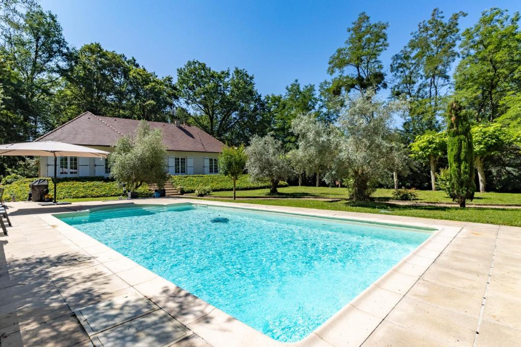 a swimming pool in front of a house at La Villa Cyrano - Maison avec piscine privée in Bergerac