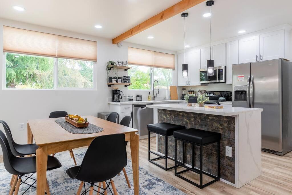 a kitchen with a table and chairs and a kitchen with stainless steel appliances at Wren Home in Concord