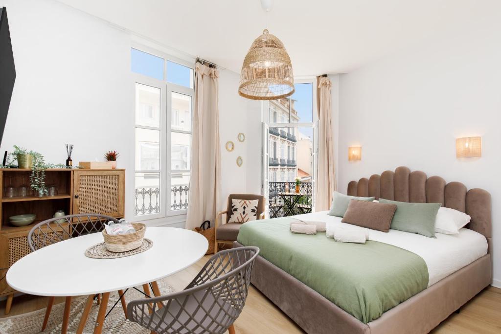 - une chambre avec un lit, une table et des chaises dans l'établissement Studio proche Croisette et centre, à Cannes