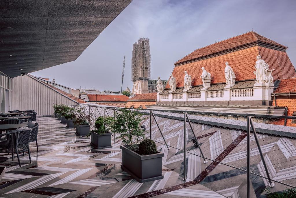 een balkon met tafels en potplanten en een gebouw bij Met Boutique Hotel in Zagreb