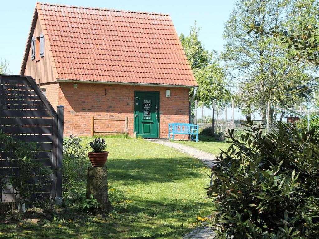 a brick house with a green door and a blue bench at Lovely Holiday Home in Zierow with Terrace in Zierow