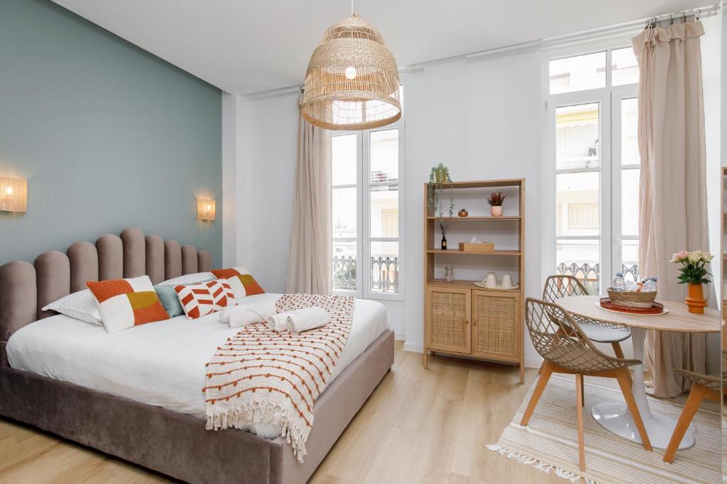 een slaapkamer met een bed en een tafel met een stoel bij Studio centre cannes in Cannes