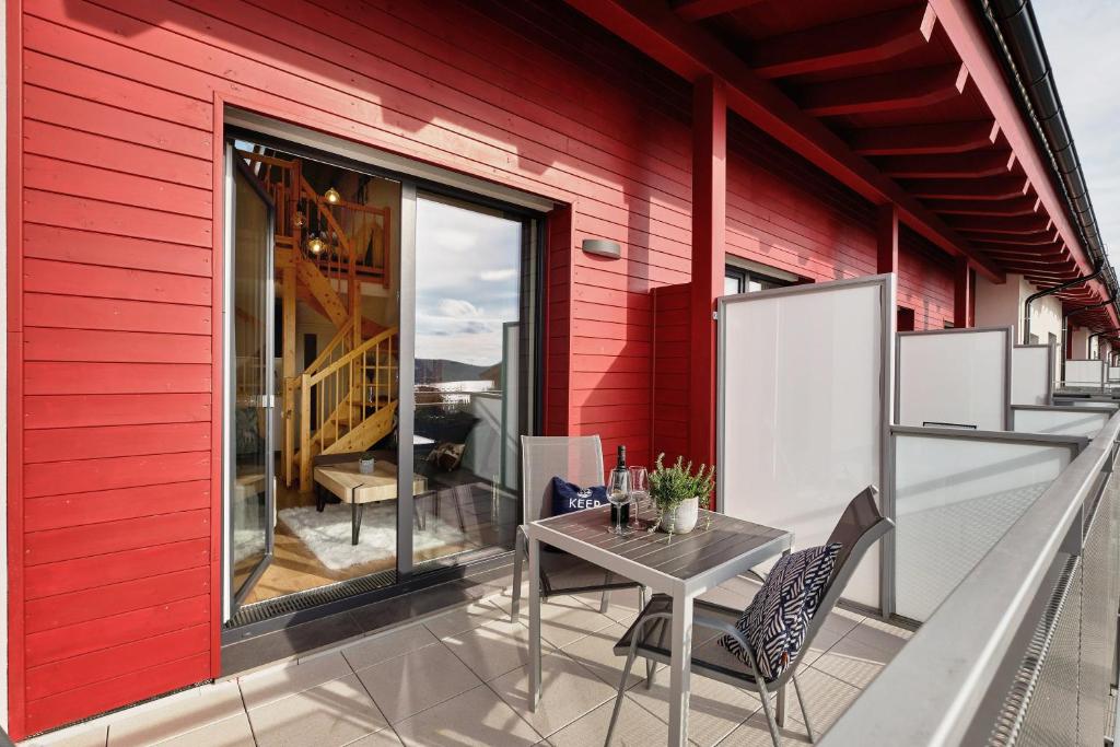 a patio with a table and chairs on a red wall at Charming and quiet apartment in Lipno nad Vltavou