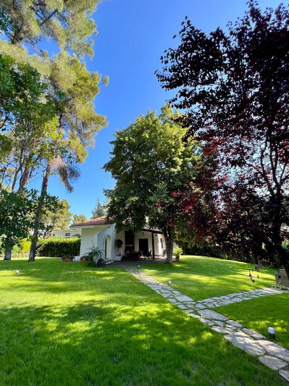 a house in the middle of a green yard at Villa Diomedes in Sani Beach