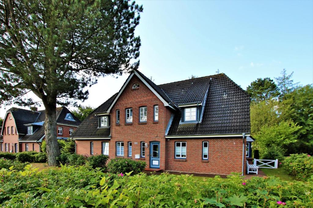 una grande casa in mattoni rossi con tetto nero di Am Gruenstreifen 33_ Whg_ 8 _Klein a Wyk auf Föhr
