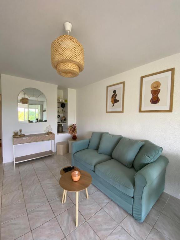 a living room with a blue couch and a table at studio confortable 30 m2 proche plage in La Seyne-sur-Mer