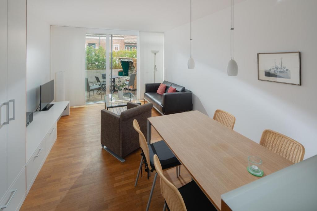- une salle à manger et un salon avec une table et des chaises dans l'établissement Jade 3, à Norderney