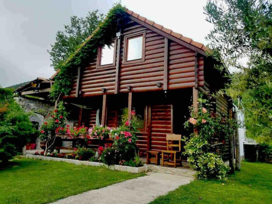 a log cabin with flowers in front of it at Top of the hill - Paradise in Ulcinj