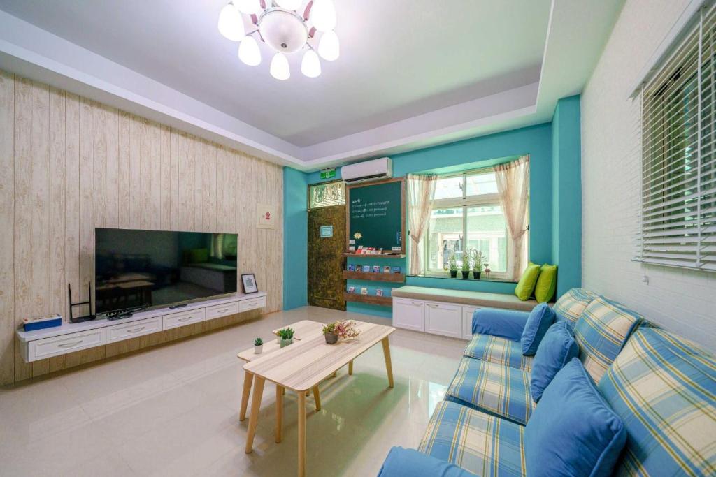a living room with a blue couch and a table at 向晴民宿 花蓮市包棟民宿 in Hualien City
