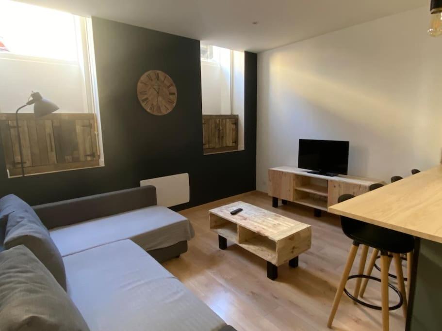 ein Wohnzimmer mit einem Sofa und einem Tisch in der Unterkunft T2 4 places 4min à pied Château in Pau