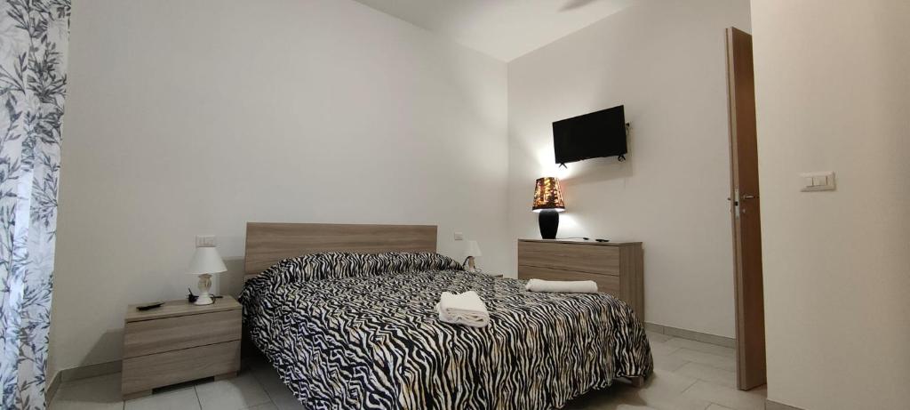 1 dormitorio con 1 cama y TV en la pared en Janara - Mura Longobarde, en Benevento