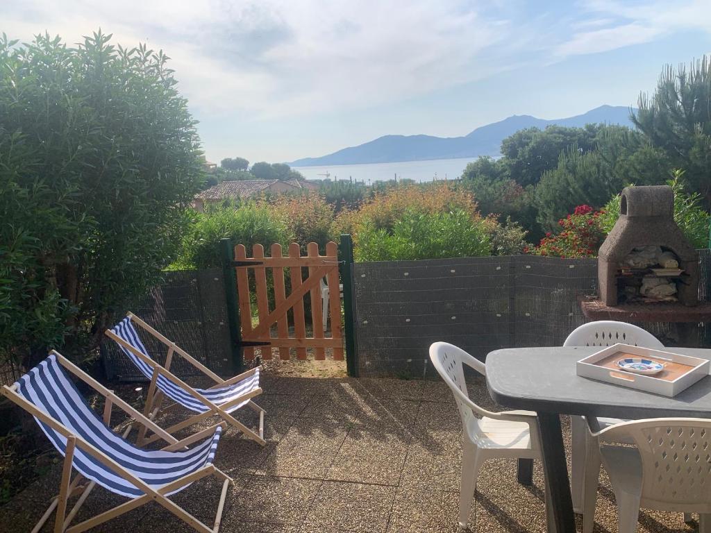 un patio avec une table et des chaises et une clôture dans l'établissement Studio Marcu vue mer, à Porticcio