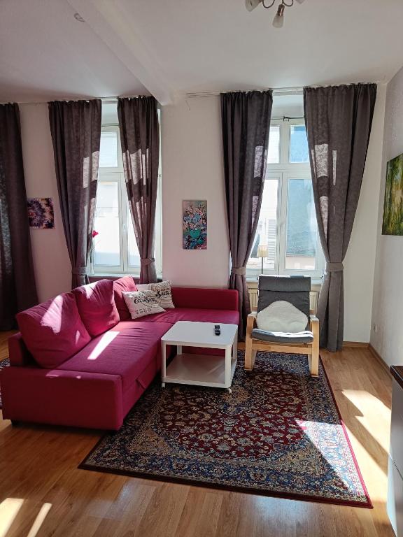 a living room with a red couch and a table at Ferienwohnung Barfly in Traben-Trarbach