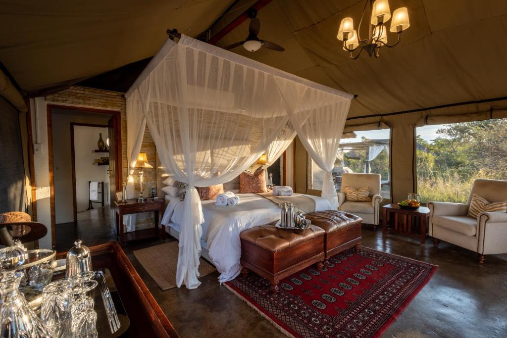a bedroom with a bed with a canopy at Safari Plains in Mabula