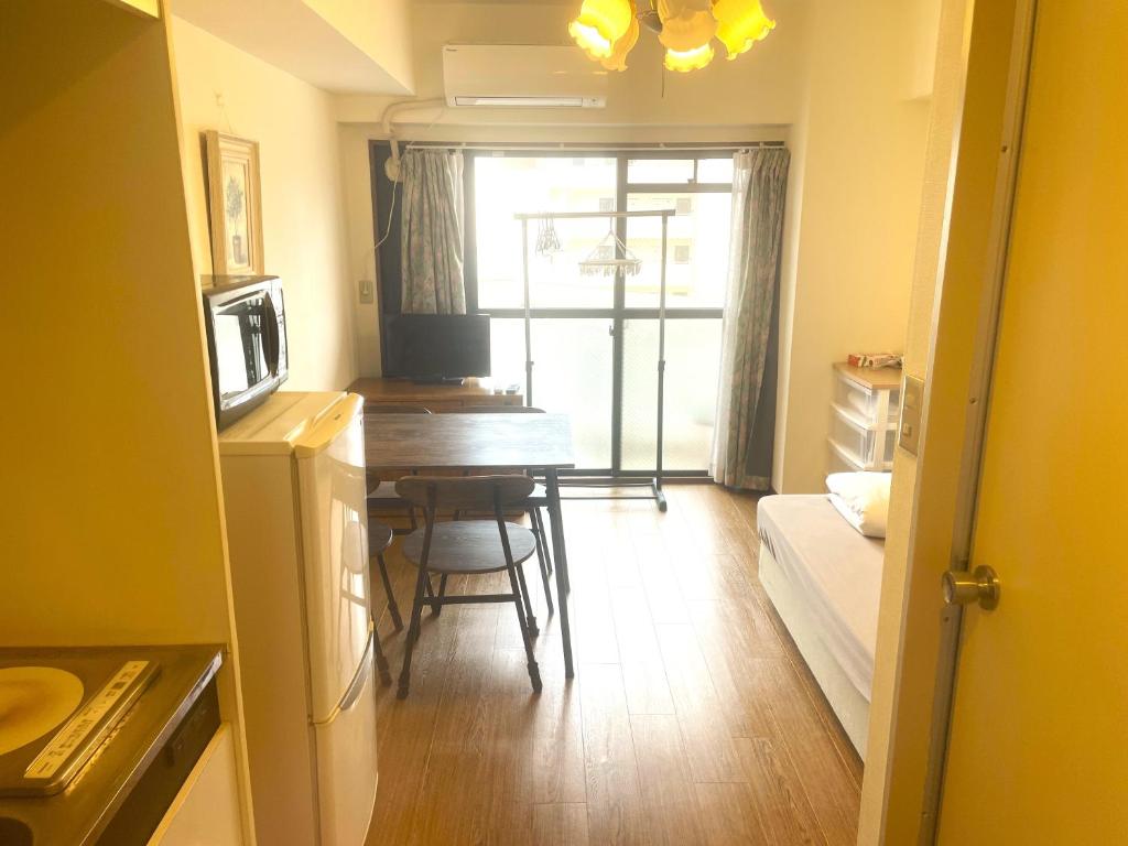 a kitchen and dining room with a table and a room at Morinomiya Flat 森ノ宮フラット in Osaka