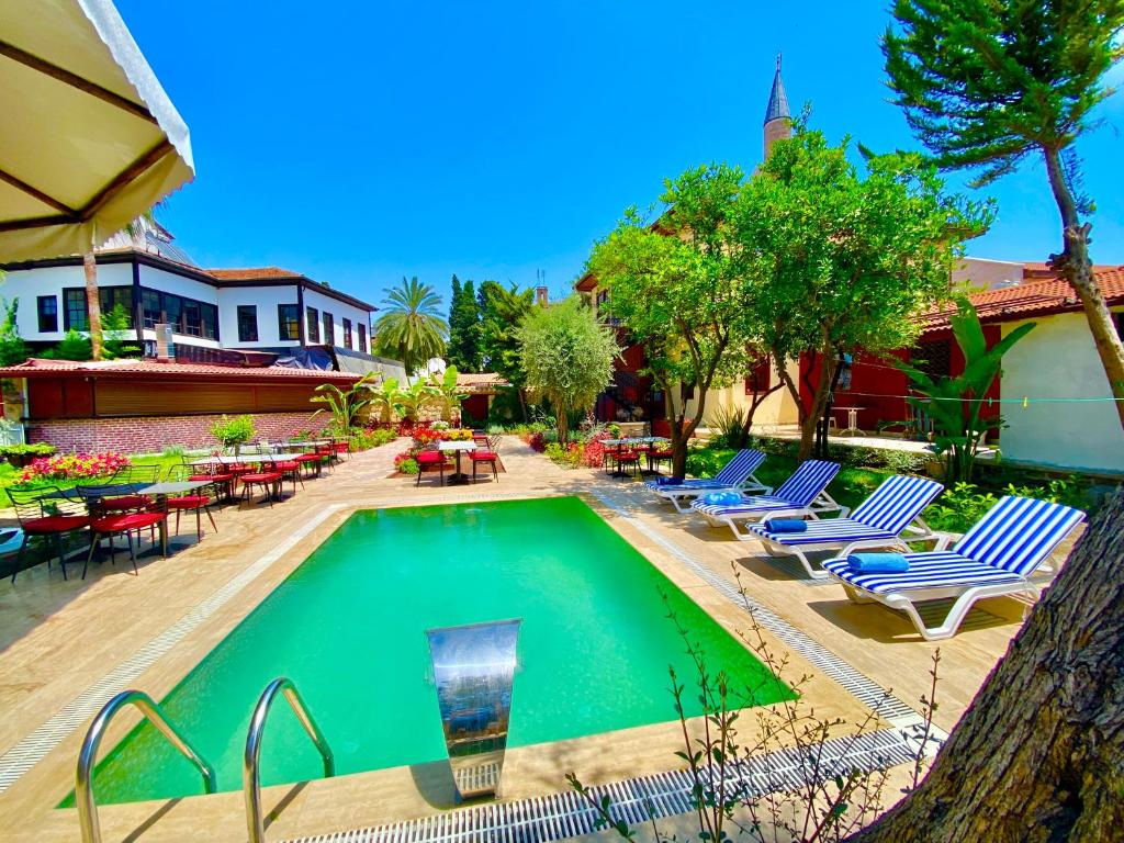 a swimming pool with lounge chairs and tables at Necip Bey Konağı in Antalya