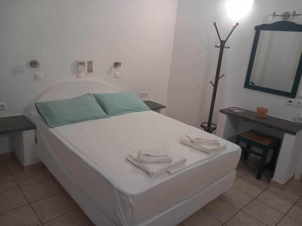 Un dormitorio con una cama blanca con toallas. en Studios Margarita, en Platis Yialos Sifnos