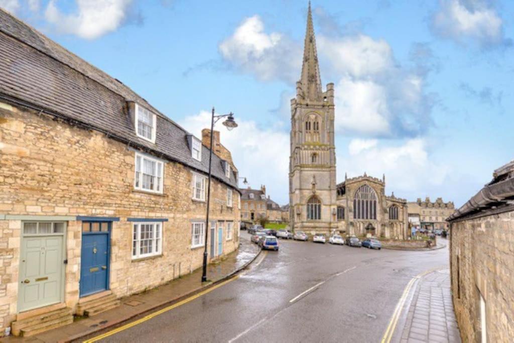 an empty street with a church and a tower at Victorian townhouse - Stamford centre - 2 big bedrooms, living room kitchen etc tastefully decorated in Lincolnshire