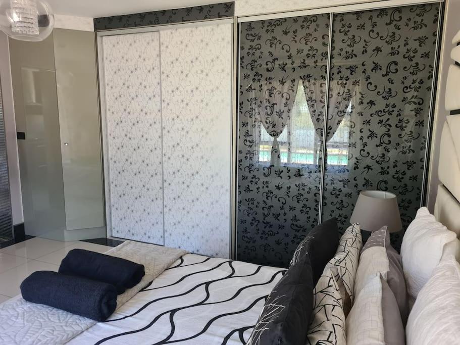 a bedroom with a bed and a large closet at Umhlanga Guesthouse flat in Durban