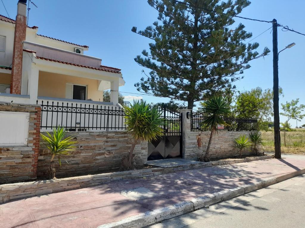 une maison avec une clôture et un arbre dans l'établissement Maria’s House Kineta, à Mégare