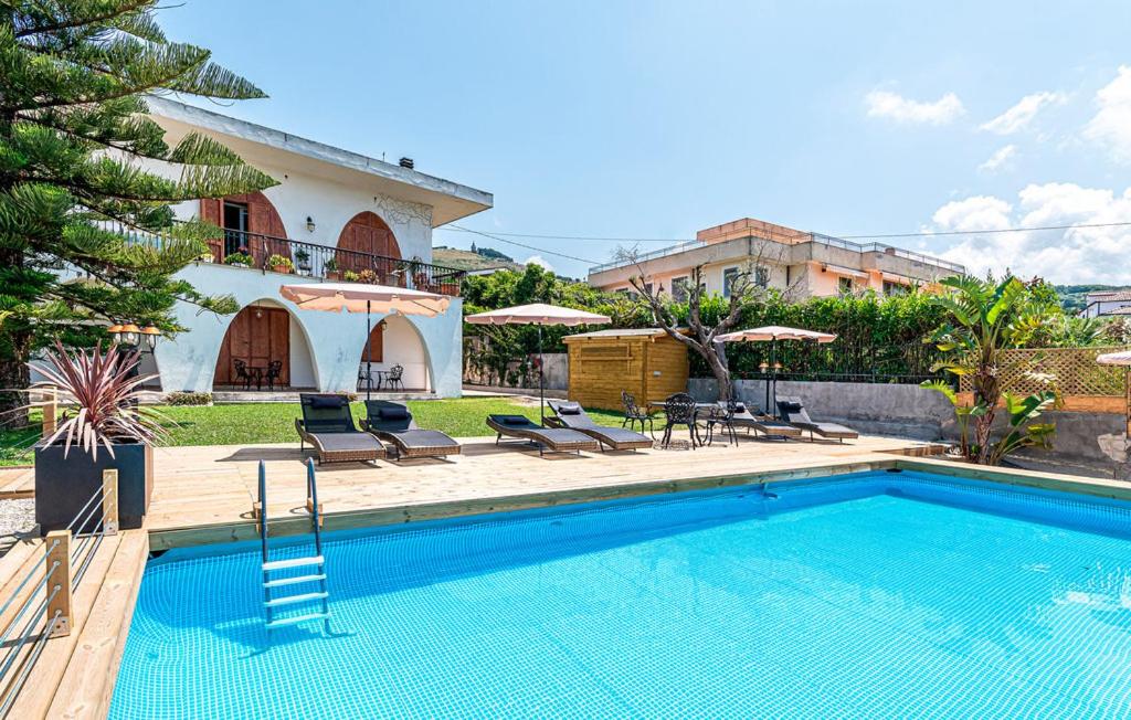 a swimming pool with chairs and a house at MaryWilliam in Agropoli